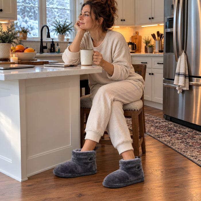 Femme qui prend son café du matin dans la cuisine avec ses bottes chauffantes La Nocte