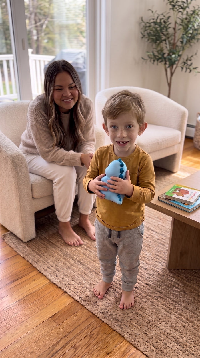 Un petit garçon montre son Dino Dit bleu à sa maman