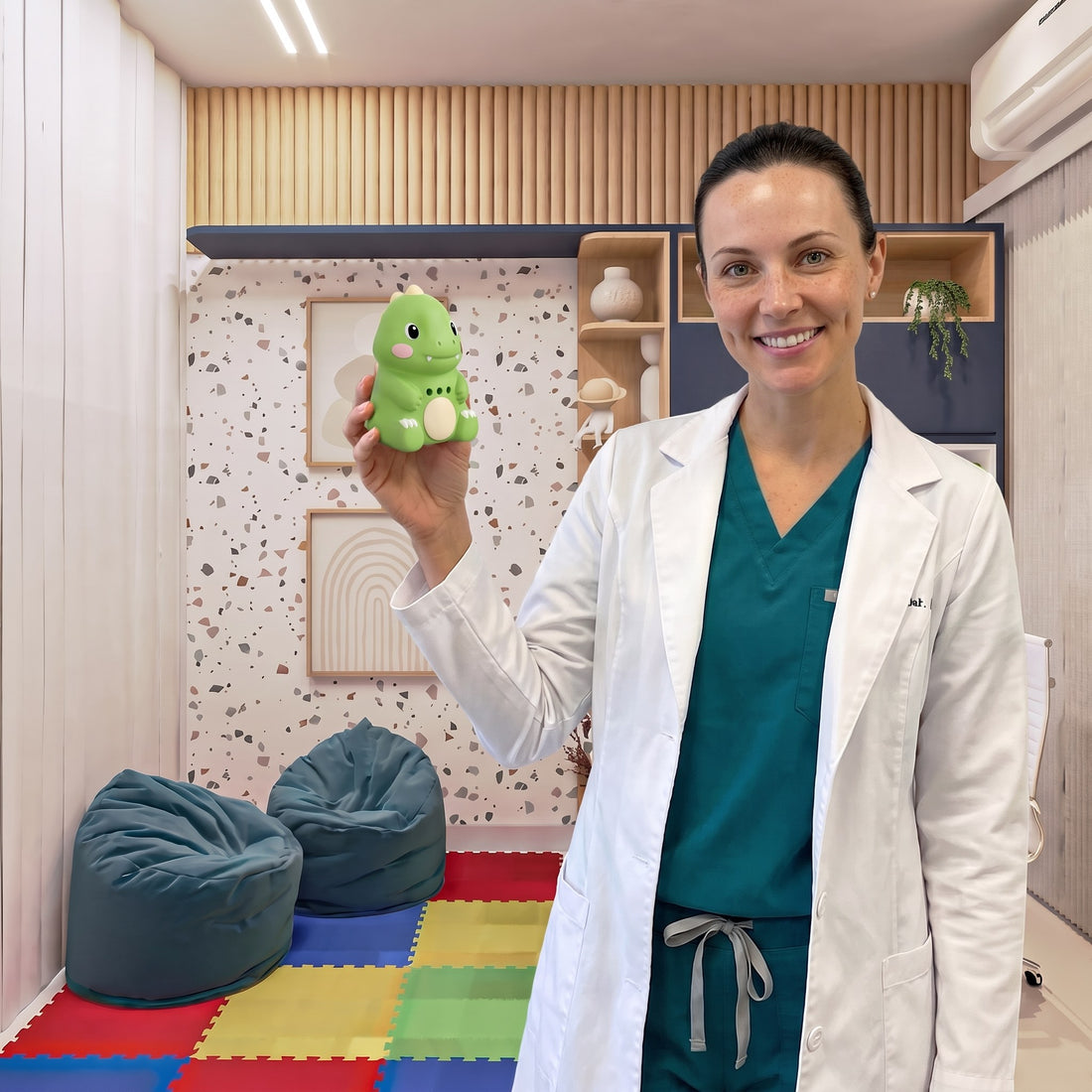 Une femme souriante tient Dino Dit vert dans une salle de jeux